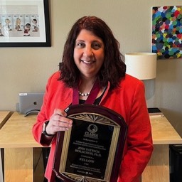 Jodi Holschuh holding her Fellows plaque