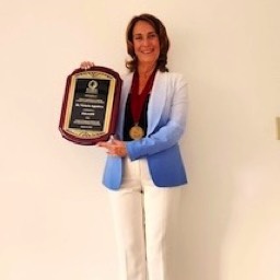 Victoria Appatova holding her Fellows plaque