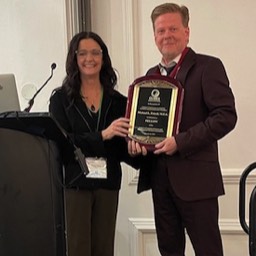 CLADEA Chair Jenny Haley presenting a Fellows plaque to Fellow Michael Frizell