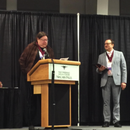 Fellows Inductee Janet Norton speaking while Fellow Russell Hodges looks on